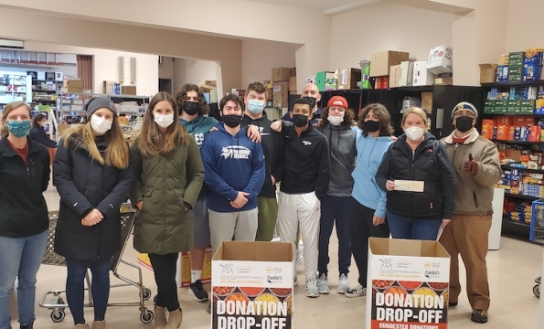 group of people wearing masks standing together in a food pantry