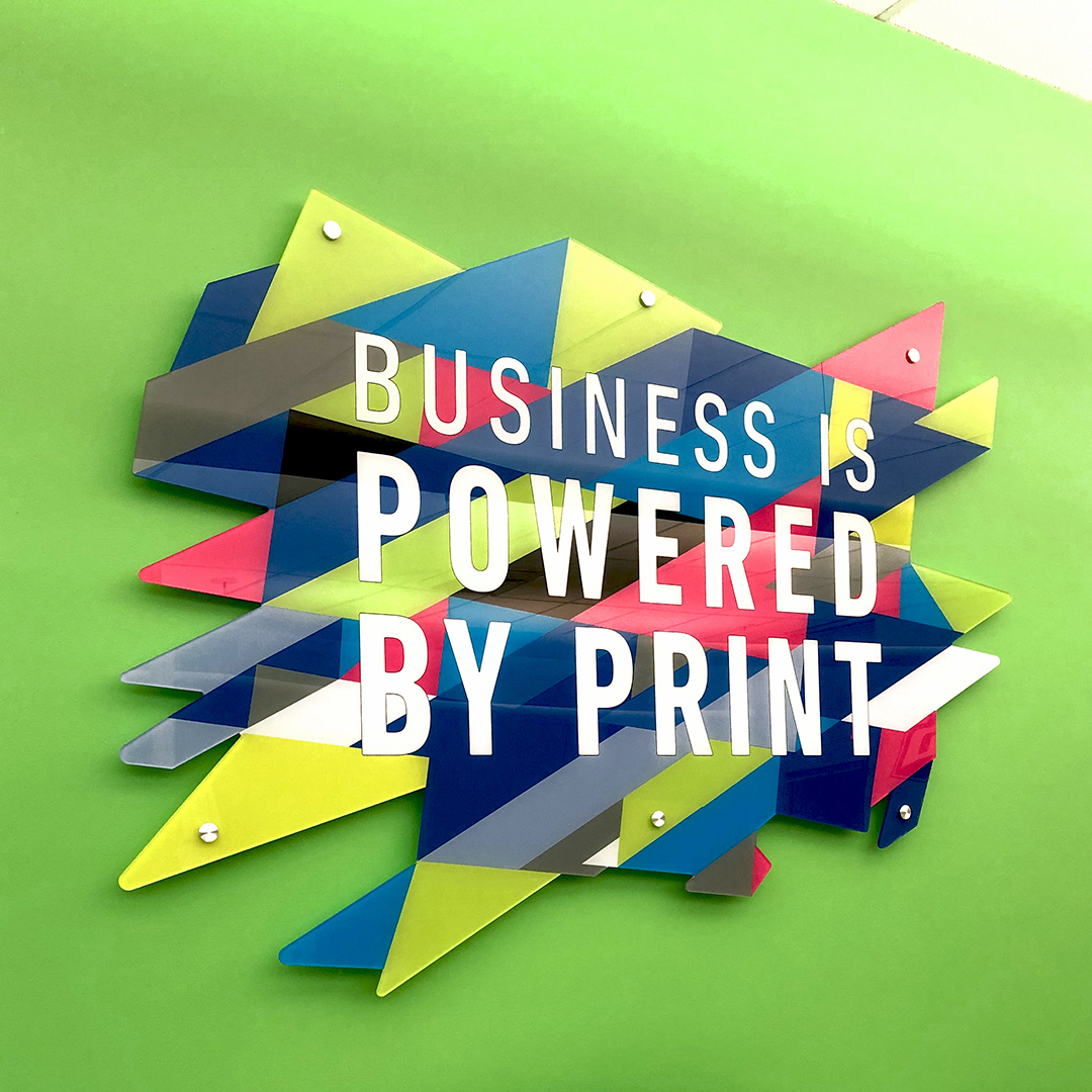 Brightly colord wall decor reading "business is powered by print"