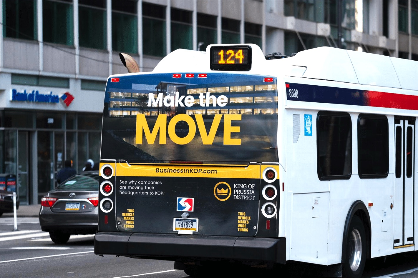 The back of a bus with an advertisement on it reading "MAKE THE MOVE"