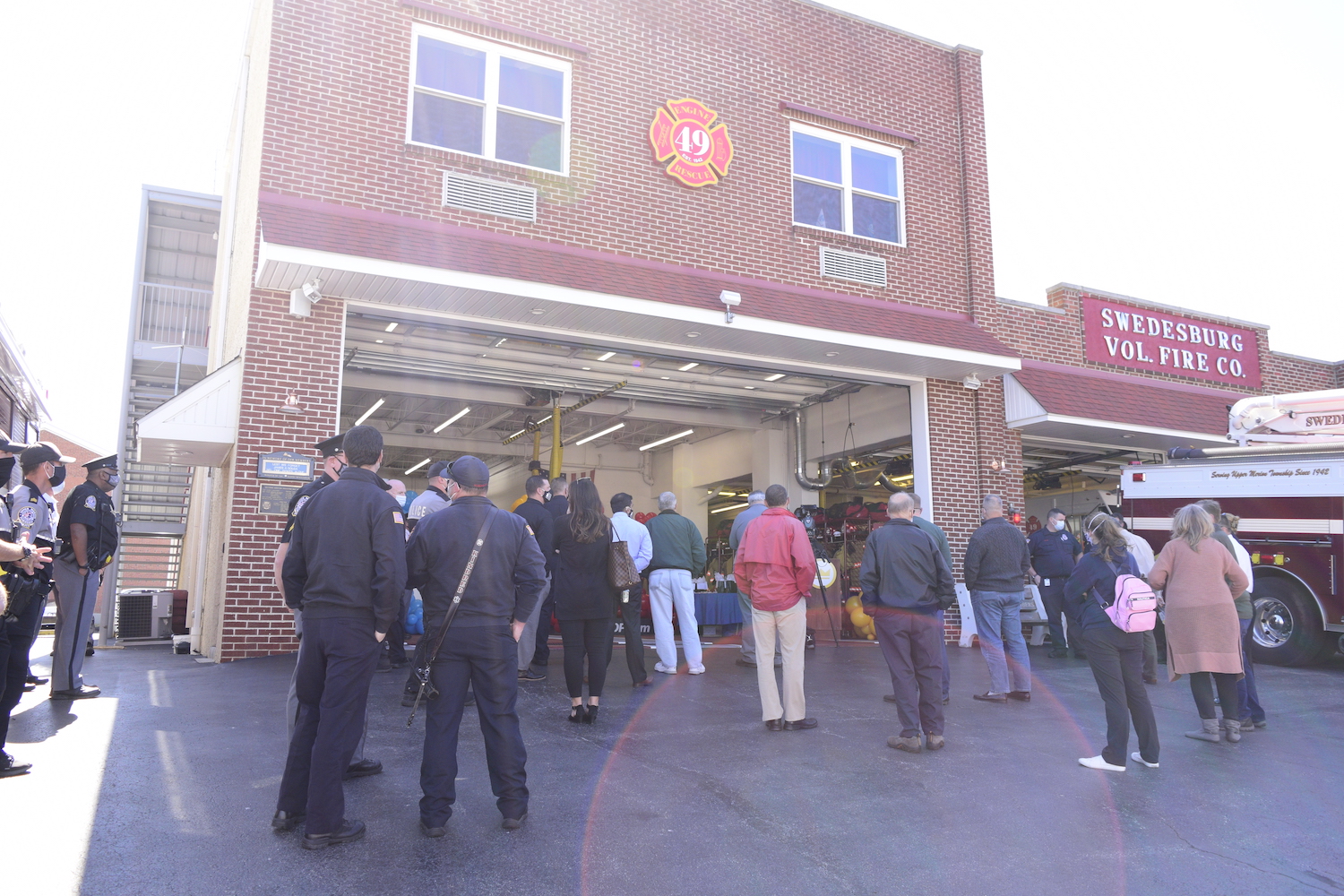 crowd of people standing outside a fire house