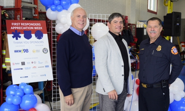 three people standing in front of red, white and blue balloons smiling