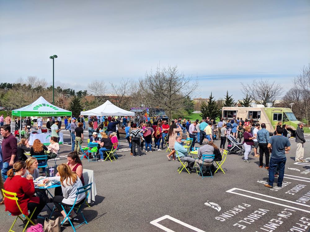 small groups of people, food trucks and product stalls