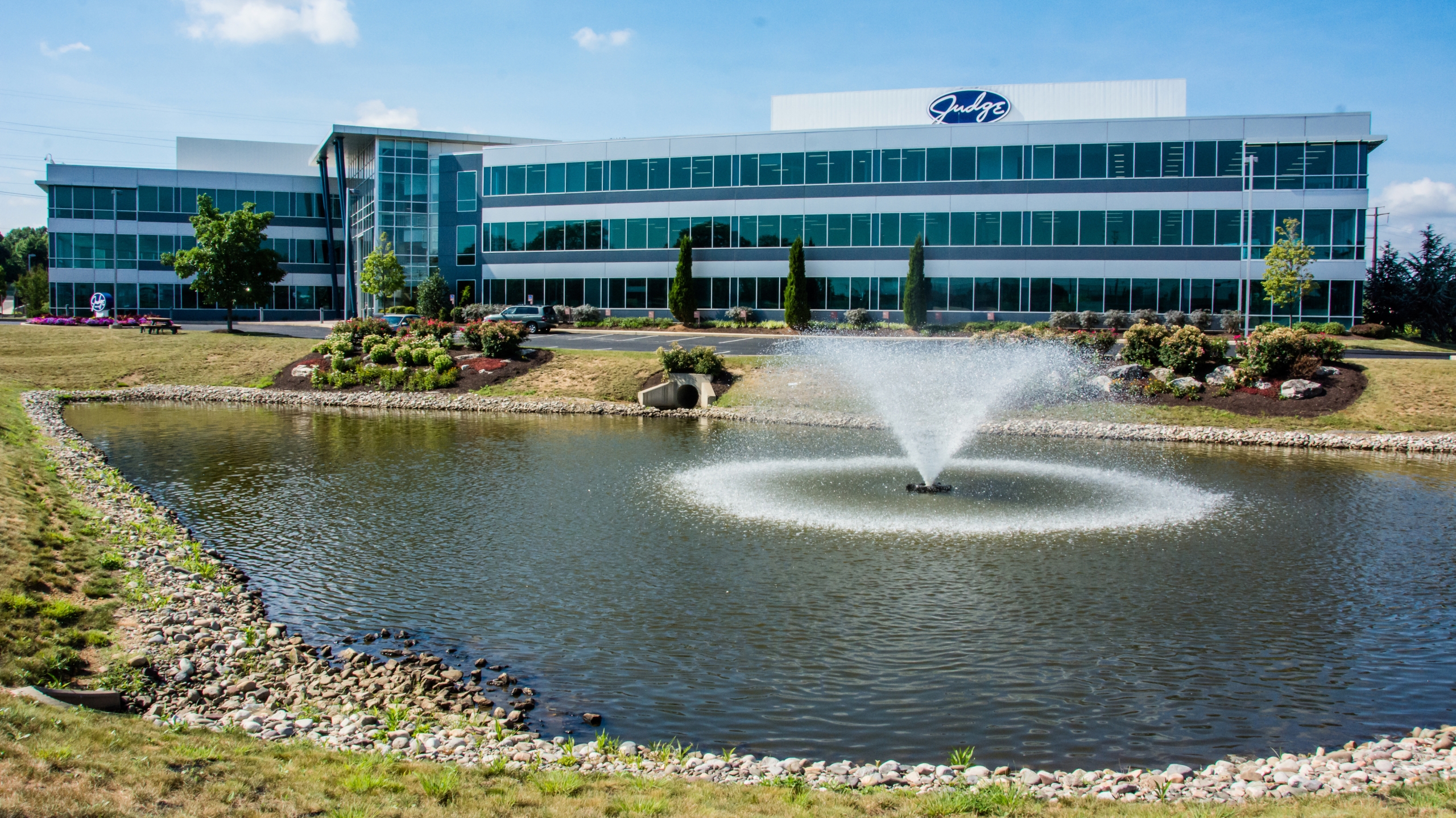 a large lake with fountain spraying water and a building in the background