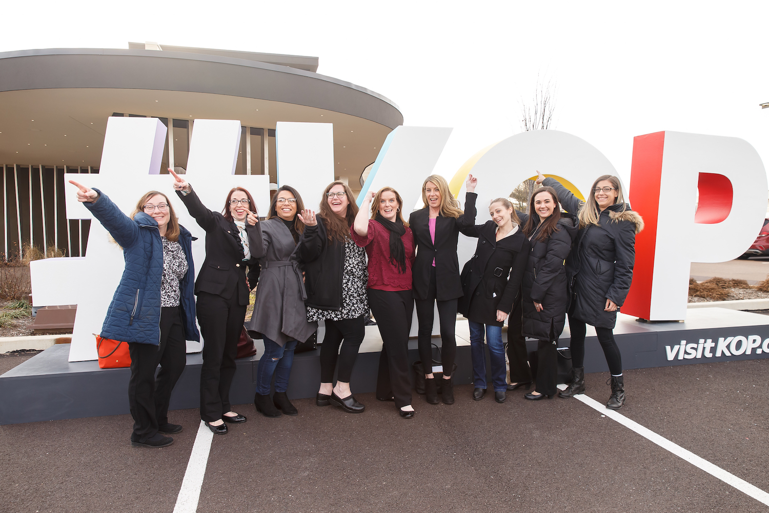 group of women standing in front of giant letters