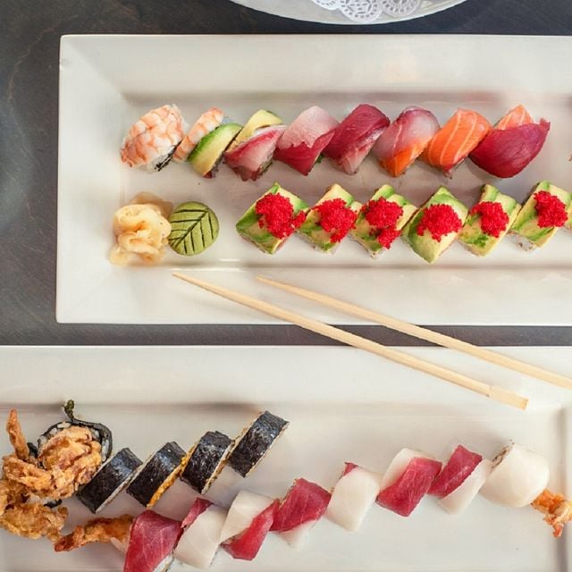 aerial view of two rectangular plates filled with colorful sushi rolls