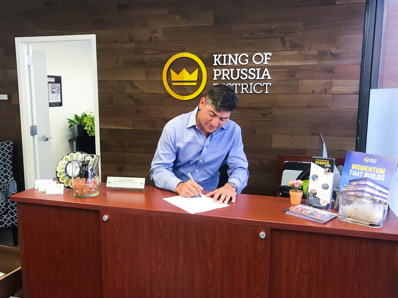 King of Prussia District Executive Director Eric Goldstein signing piece of paper on desk
