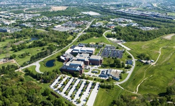 aerial view of buildings, parking lots and greenery