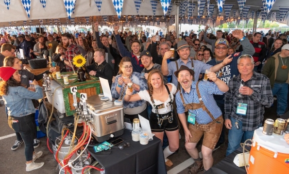 group of people holding up small beer mugs and smiling