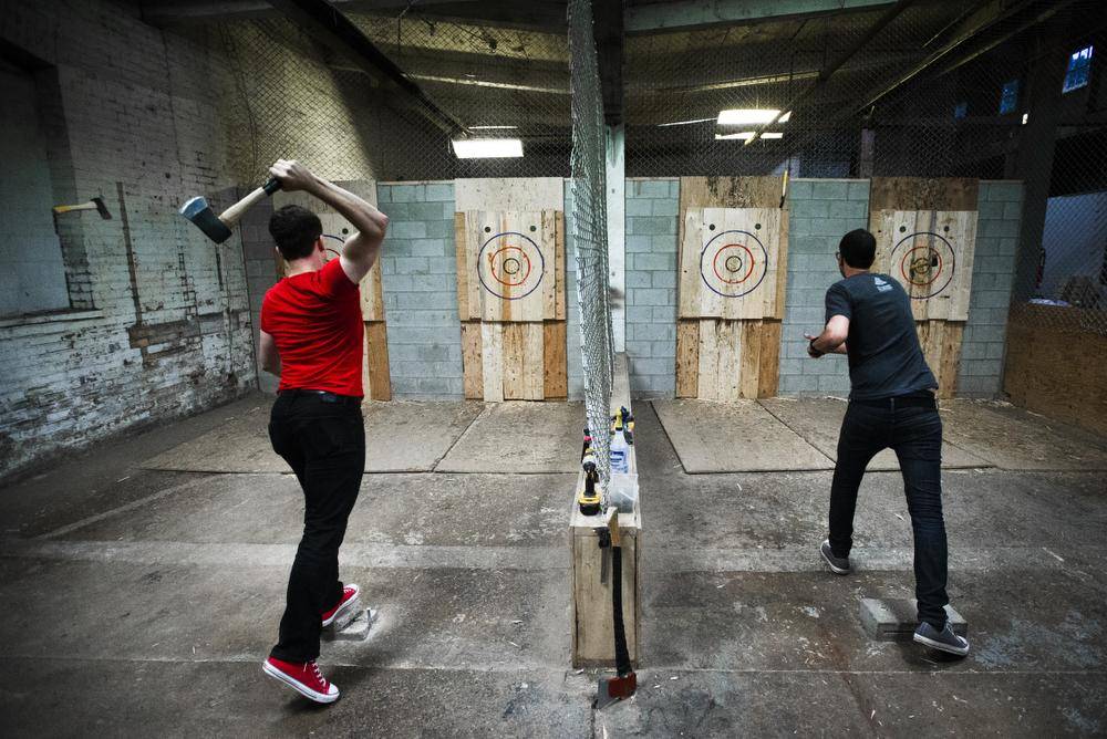2 people throwing axes at targets