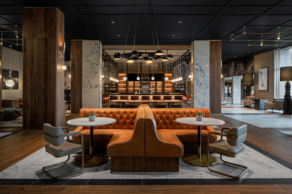 colorful orange couch with round tables and light fixtures