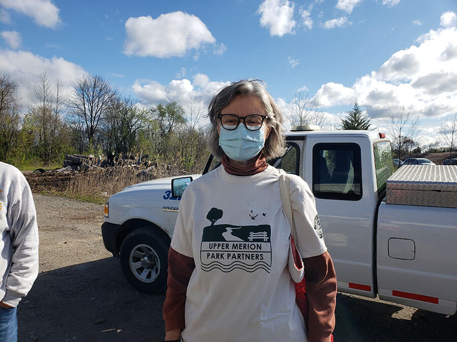 woman with face mask standing in front of a truck