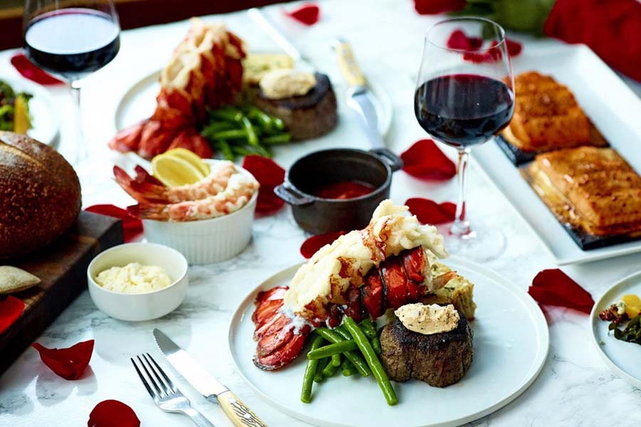 lobster dinner on table with red wine