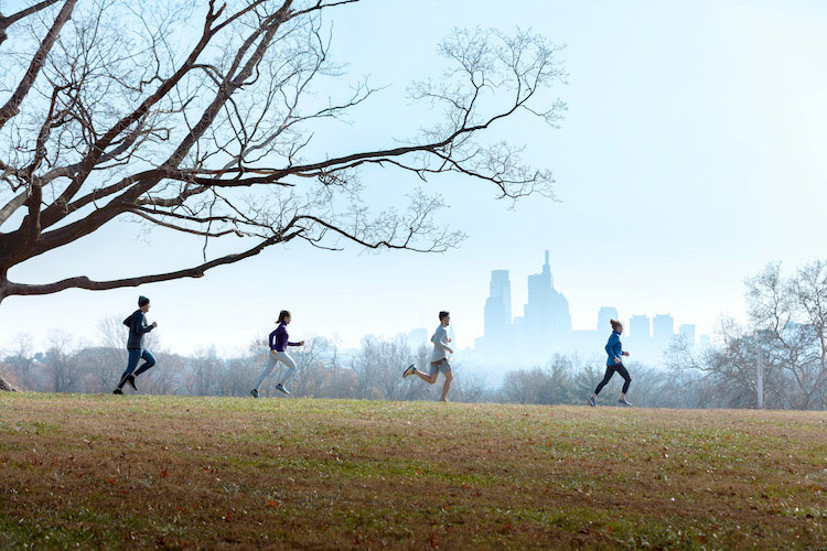 people running with city skyline in background