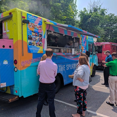 people standing outdoors by a food truck