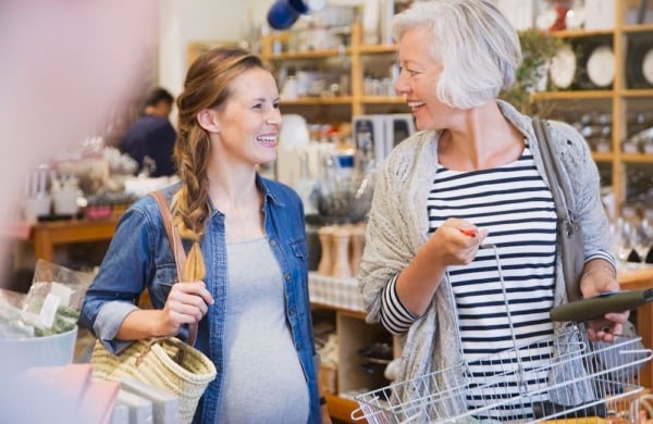 pregnant woman smiling next to an older woman in a store