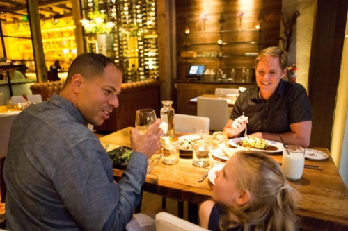 two fathers looking at young daughter