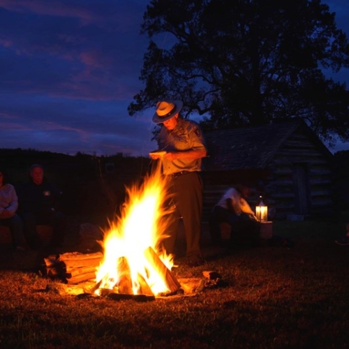 person standing by a fire at night