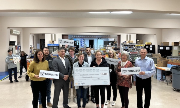group of people holding a large check
