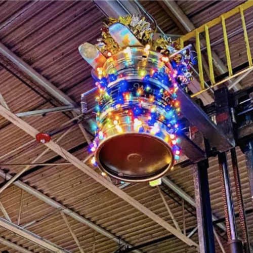 A keg with lights on it up by the ceiling