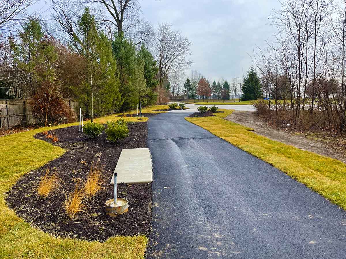 paved walkway surrounded by grass and landscaping