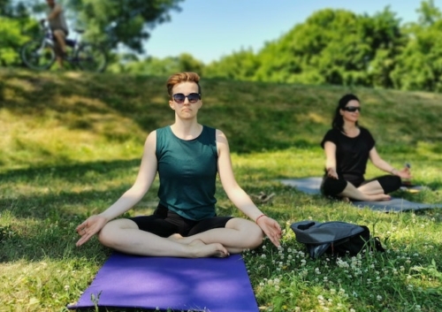 person in a yoga pose on a mat outdoors