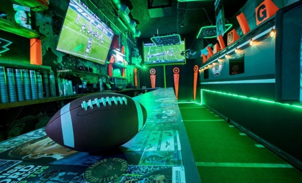 football on a bar table that is lit up green
