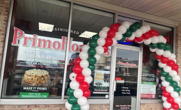 exterior of Primo Hoagies storefront, with a balloon arch in front of the door