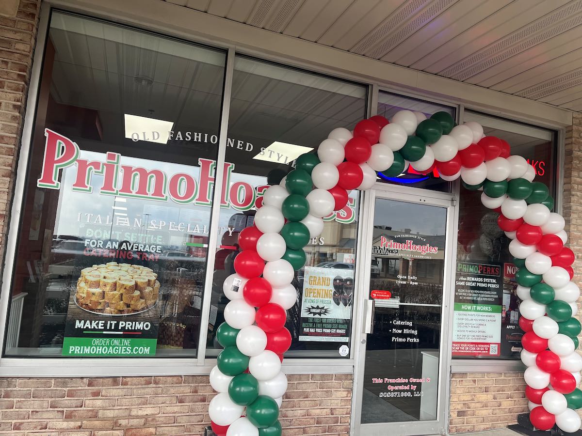 exterior of Primo Hoagies storefront, with a balloon arch in front of the door