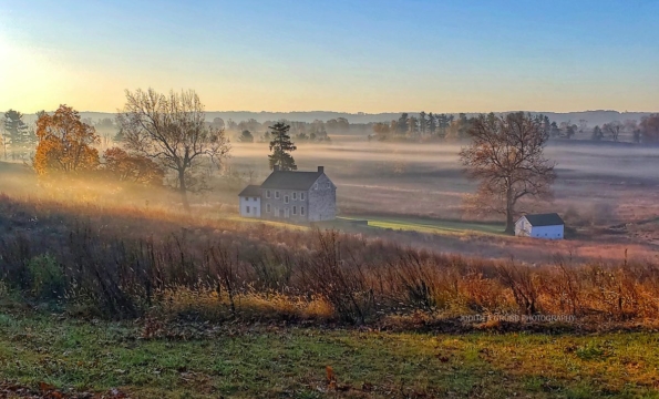 a vast meadow with a house in the distance