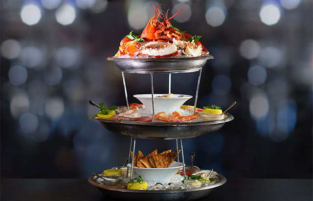 three level tower of plates filled with seafood