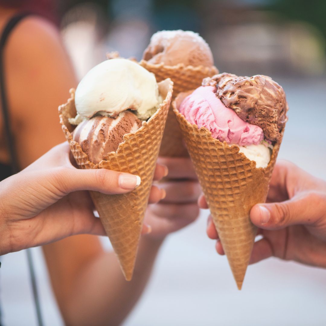 three hands holding up ice creams