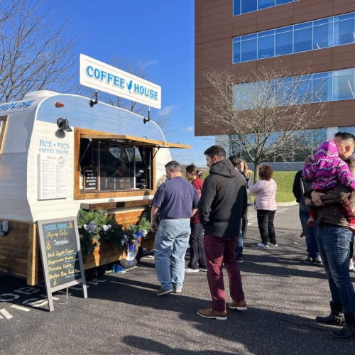 group of people in line at a mobile cafe