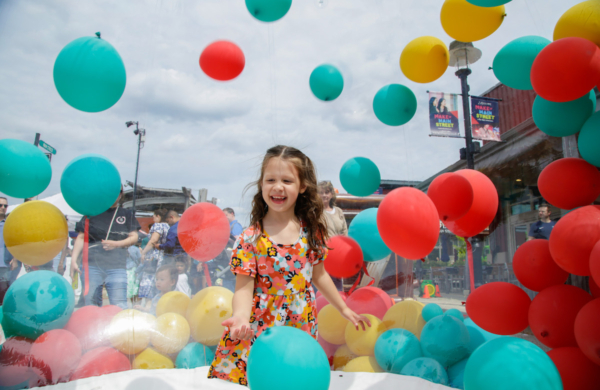 child amongst colorful balloons
