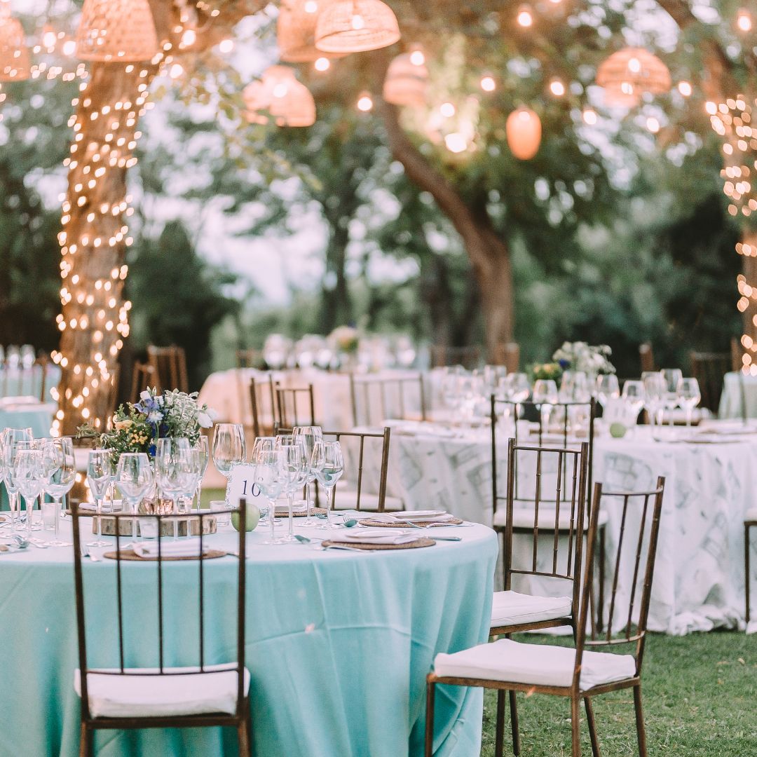 tables set up outdoors with bistro lighting