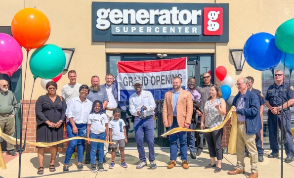 people standing in front of generator supercenter building smiling and cutting a ribbon