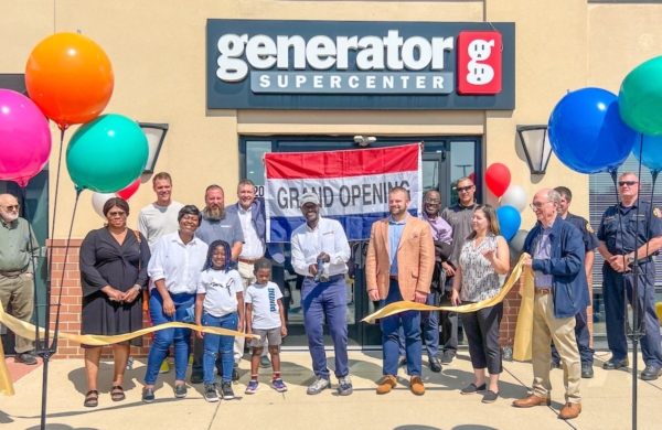 people standing in front of generator supercenter building smiling and cutting a ribbon