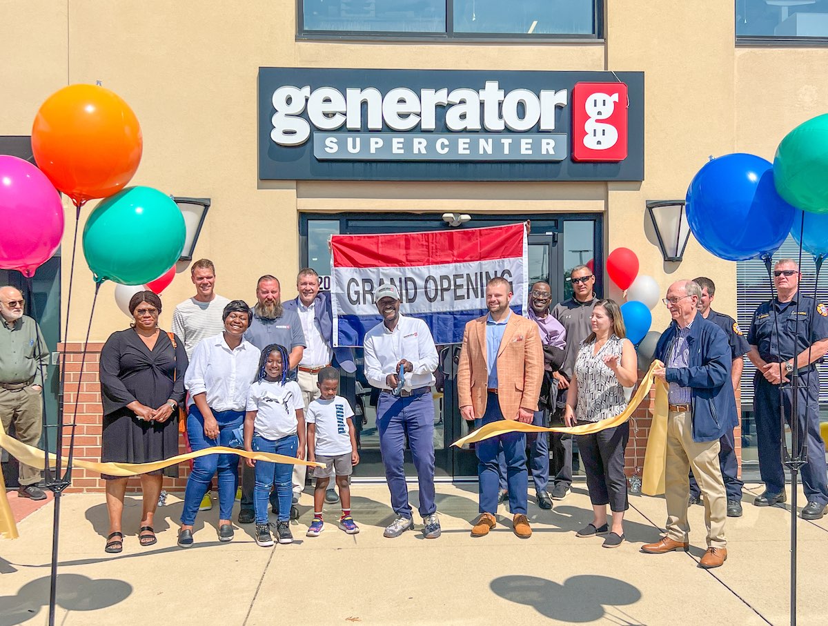 people standing in front of generator supercenter building smiling and cutting a ribbon