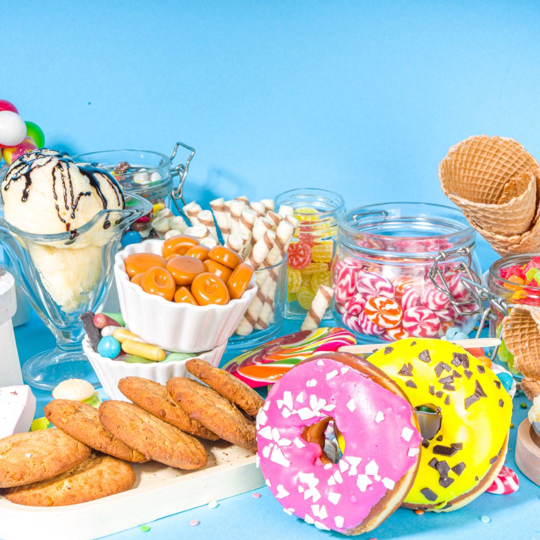 brightly colored donuts and candy on a blue surface