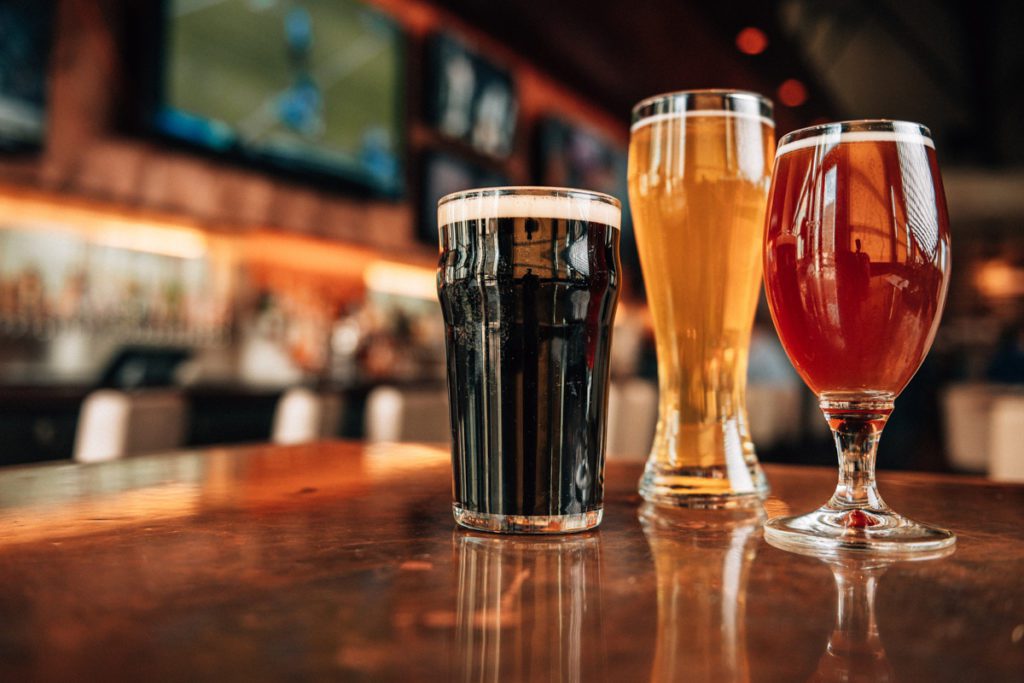 3 beers sitting on a bar