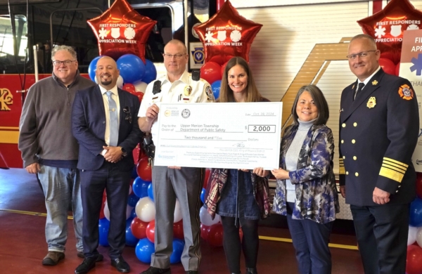 Group of people smiling and holding a large check