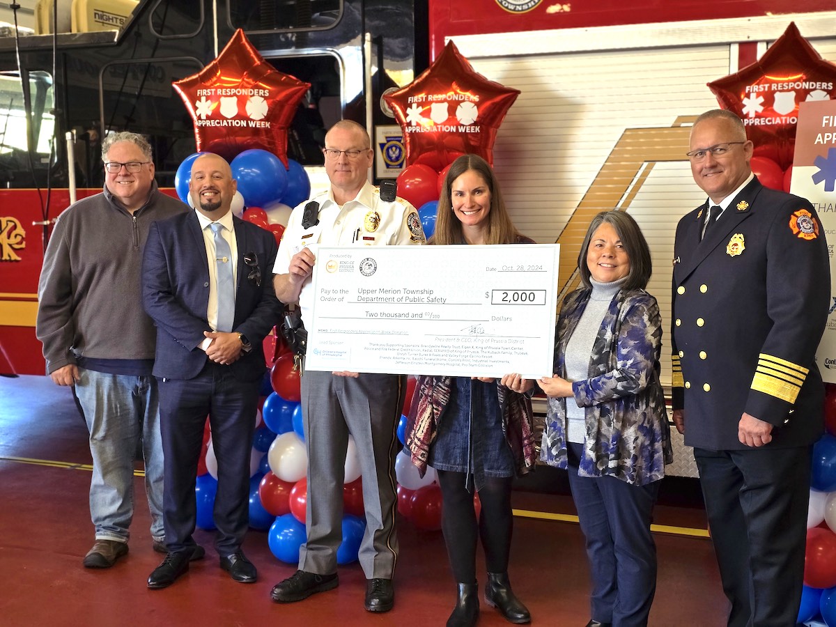 Group of people smiling and holding a large check