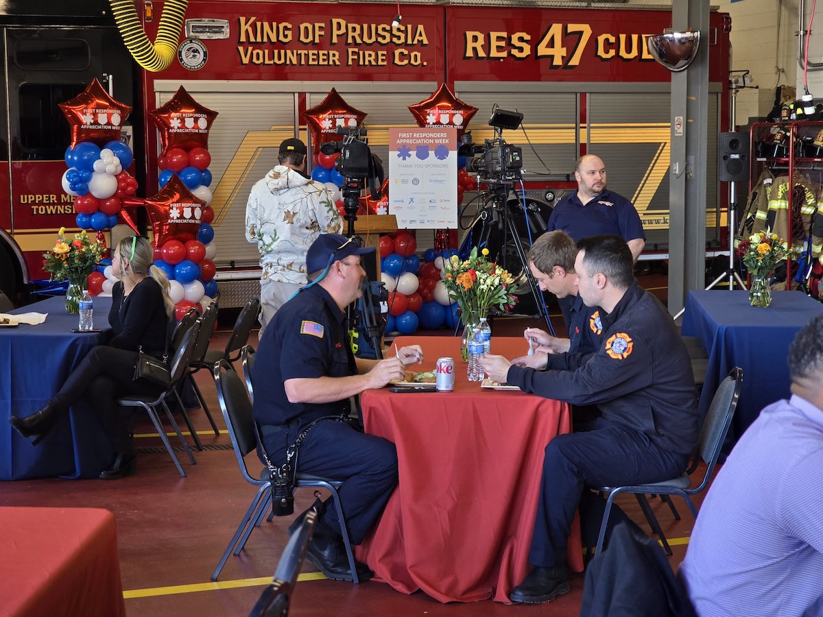 EMT and polica officers sitting at a table eating