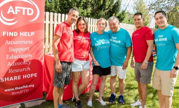 Group of people outdoors in front of an AFTD sign