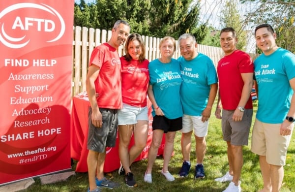 Group of people outdoors in front of an AFTD sign