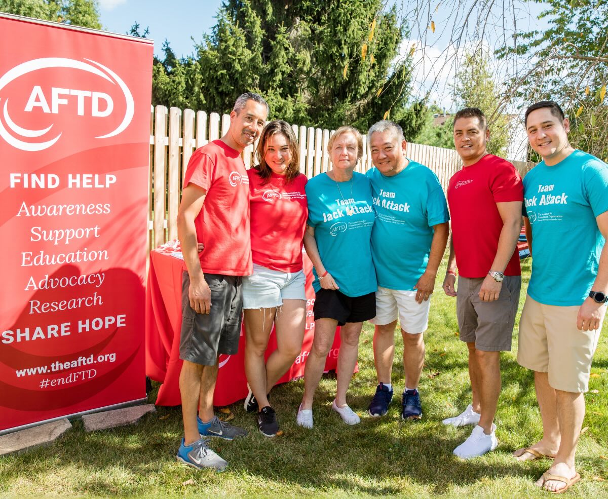 Group of people outdoors in front of an AFTD sign
