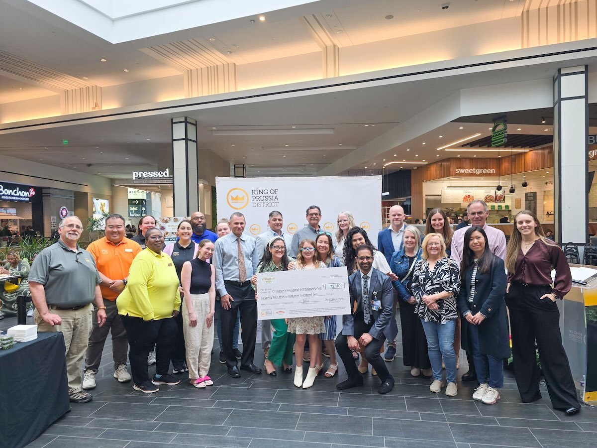 group of people smiling holding a large check