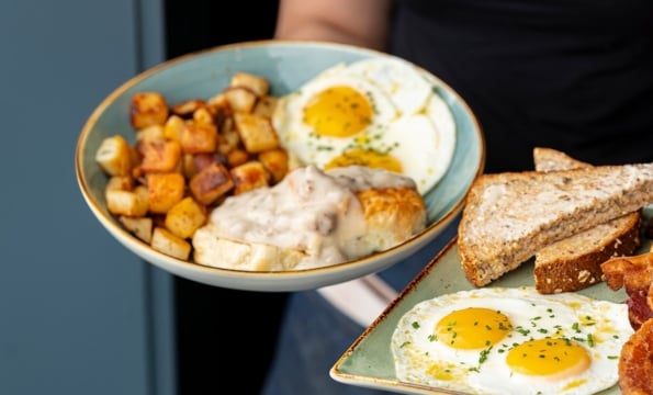 person holding bbreakfast plates