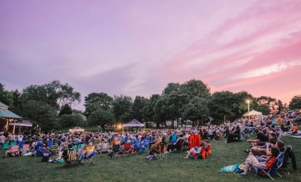 people sitting on a lawn at sunset