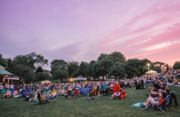 people sitting on a lawn at sunset