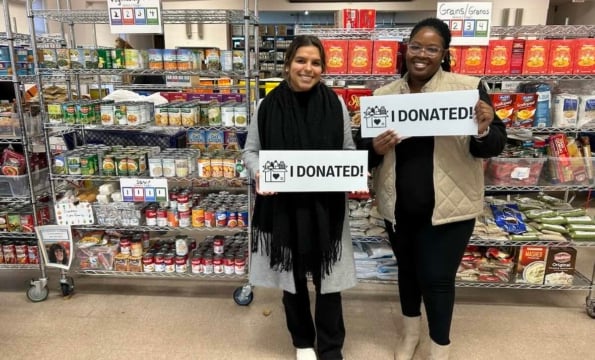 two people holding up "I DONATED" signs at Upper Merion Area Community Cupboard
